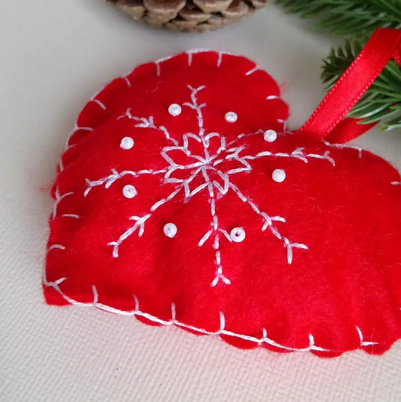 Décoration de sapin cœur rouge, broderie de flocons en gros plan