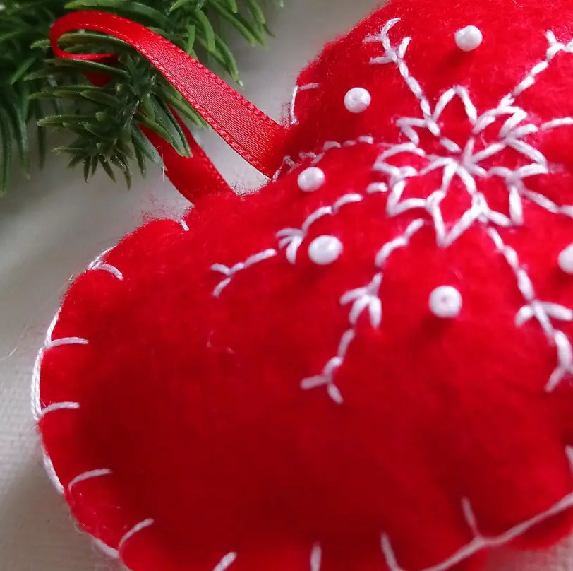 Décoration de Noël cœur rouge accrochée sur une branche de sapin