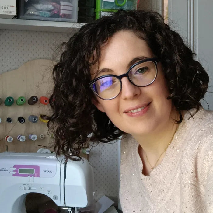 photo de la créatrice Aurélie de Récup Tissu de Lili dans son atelier avec sa machine à coudre en arrière plan