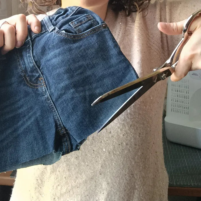 photo de la récupération de tissu en jean - découpe d'une pantalon enfant dans l'atelier de Récup Tissu de LILI