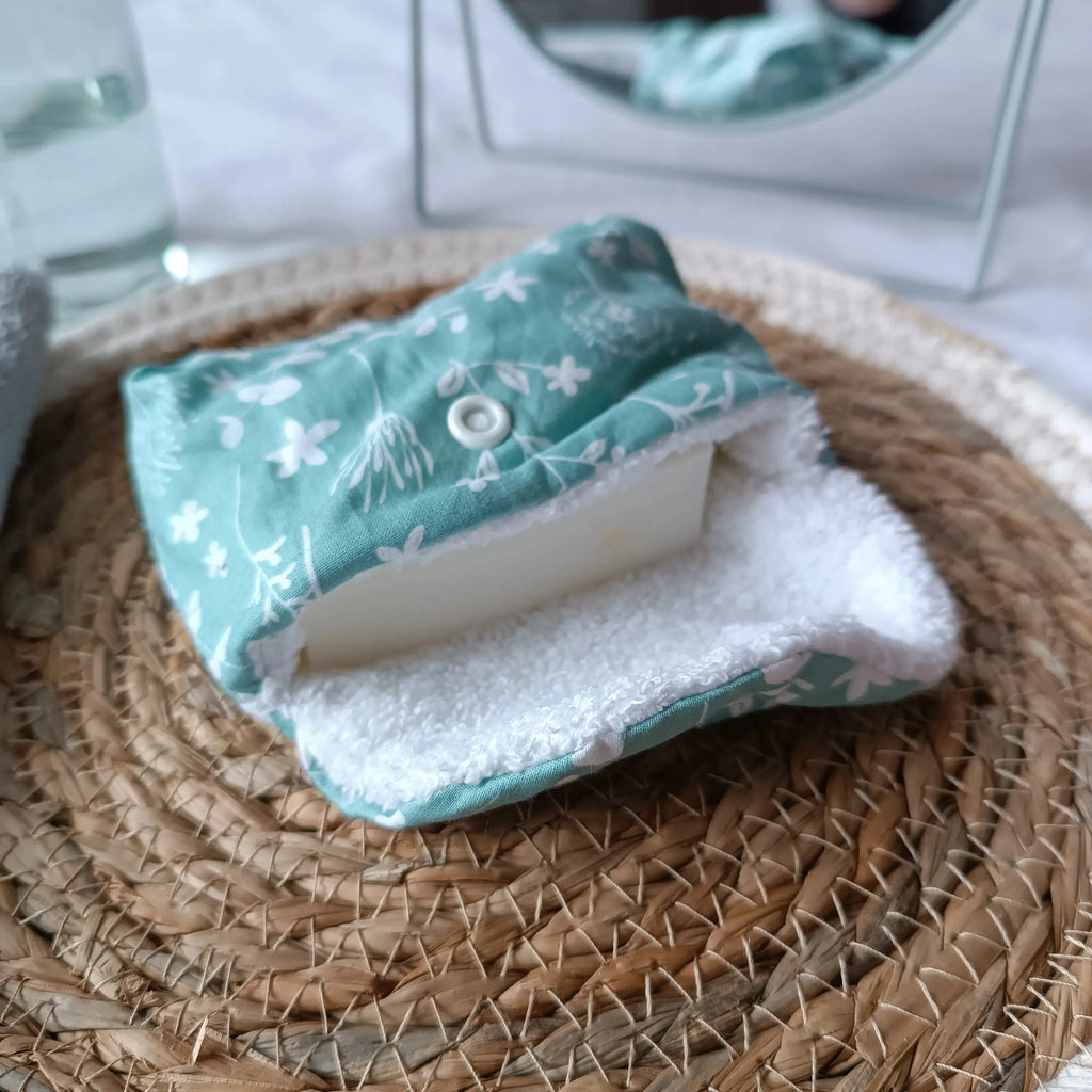 Pochette à savon artisanale verte posée dans une trousse de toilette