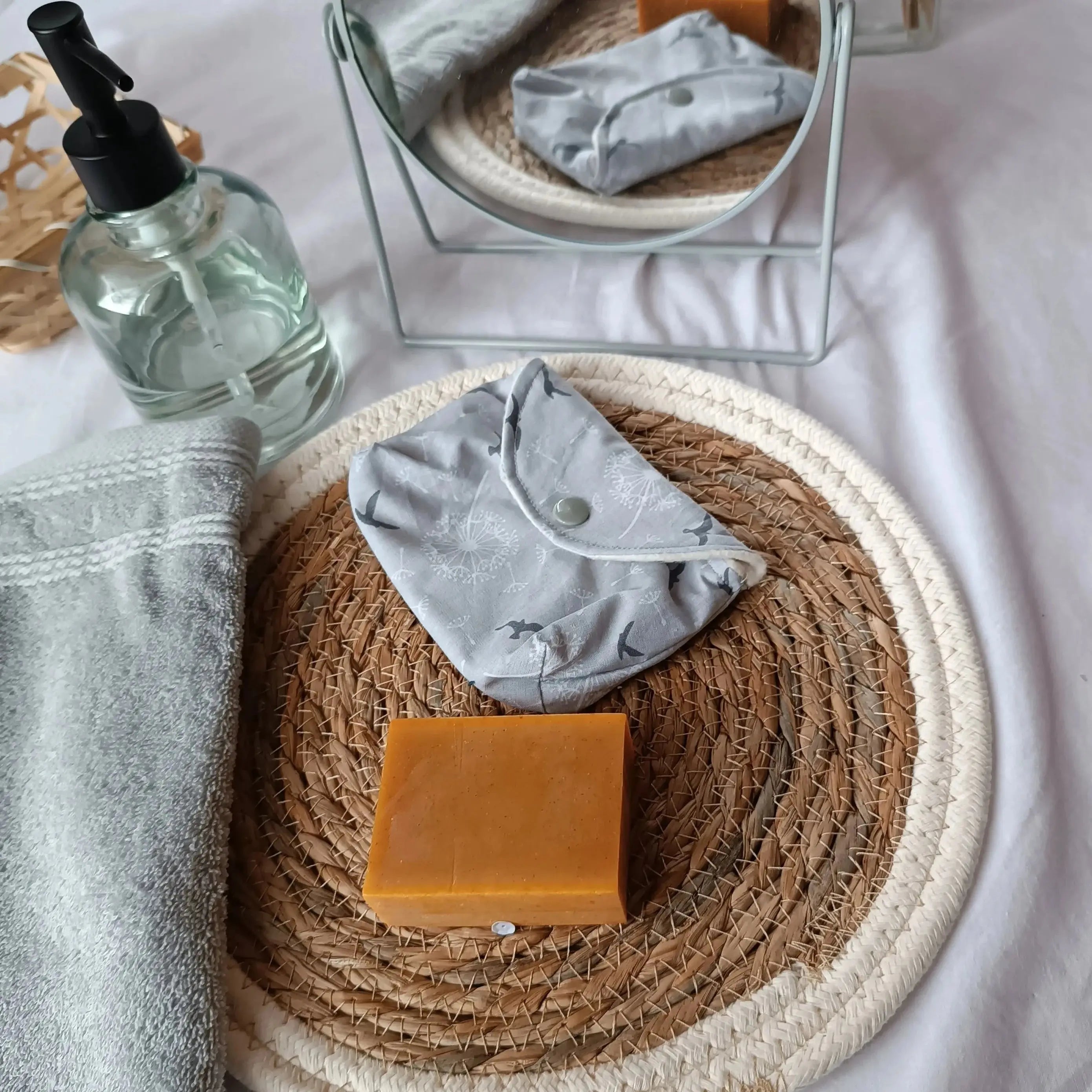 Pochette à savon artisanale grise posée dans une trousse de toilette