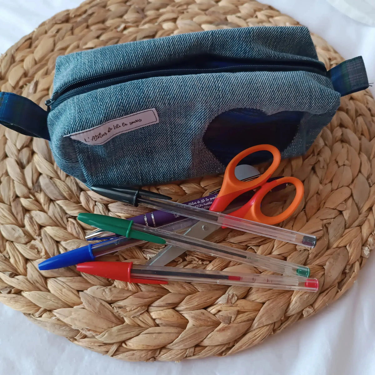 Trousse en jeans upcyclé décorée de deux cœurs en tissu
